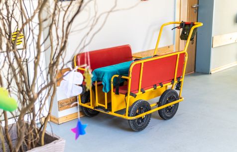 Ein rot-gelber Wagen für die kleinen Kinder steht im Flur der Klinik