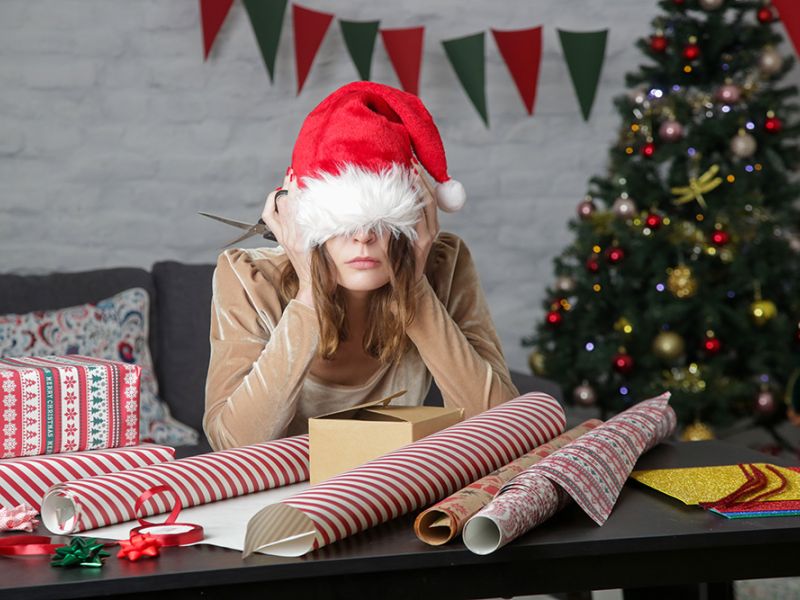 Eine Frau hat sich die Weihnachtsmütze über die Augen gezogen